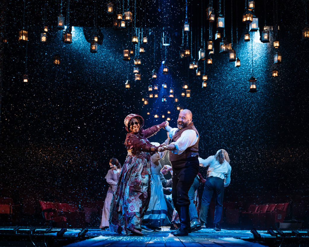 The ensemble of A Christmas Carol dance on stage at the Old Vic