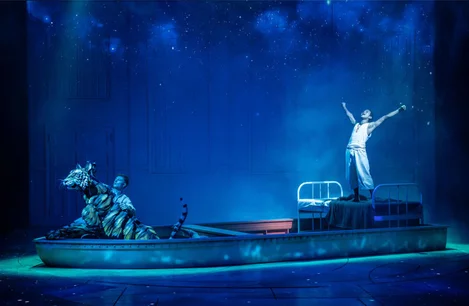 Hiran Abeysekera (Pi) and the tiger, Richard Parker (puppet led by Tom Larkin) in Life of Pi