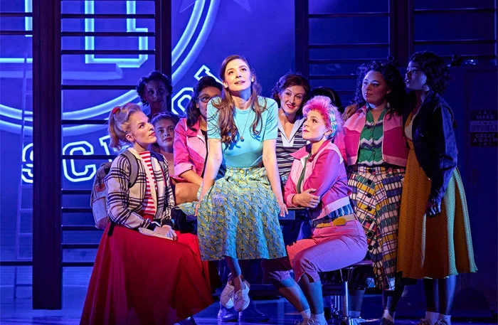 Olivia Moore (Sandy) and the company of Grease at the Dominion Theatre