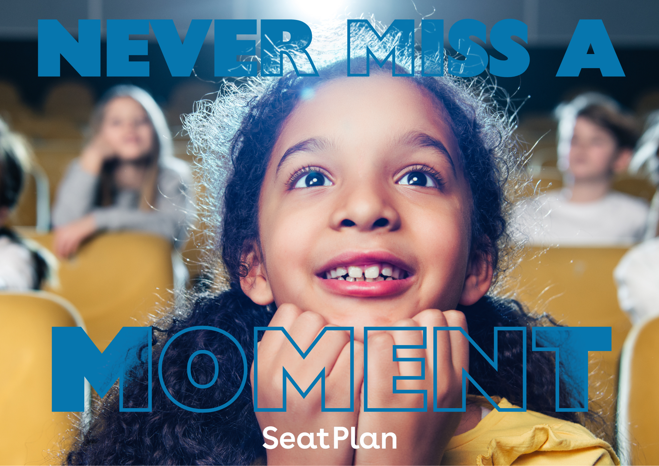 a young girl excitedly looking ahead in a theatre seat