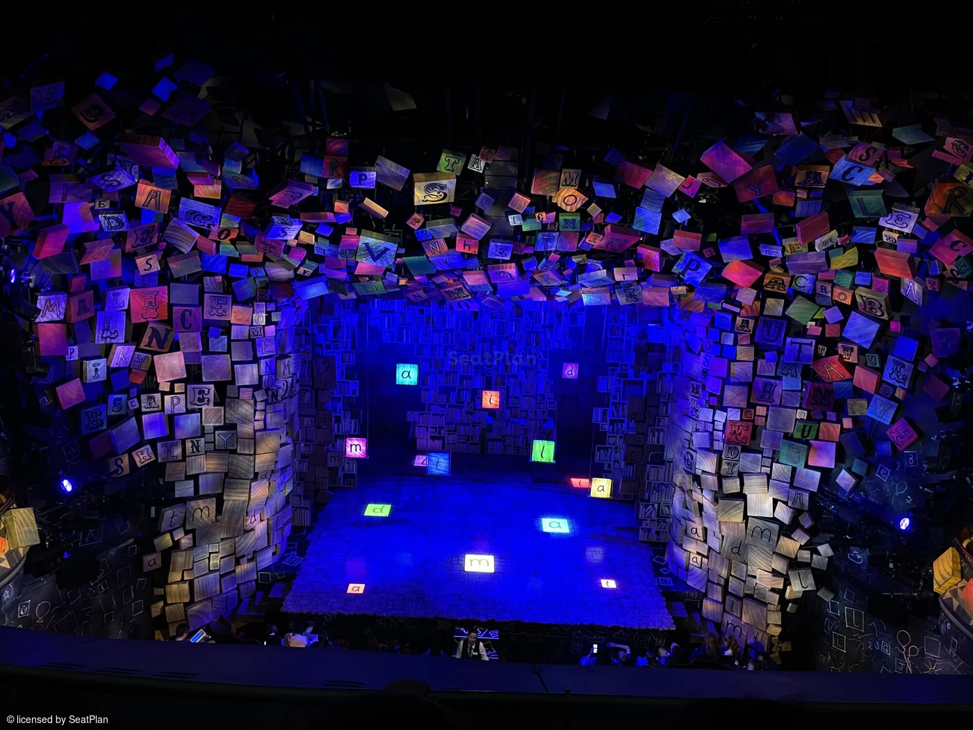 A seat view from the upper circle. It shows the colourful alphabet set, which spells out the word 'Matilda' in the centre of the stage.