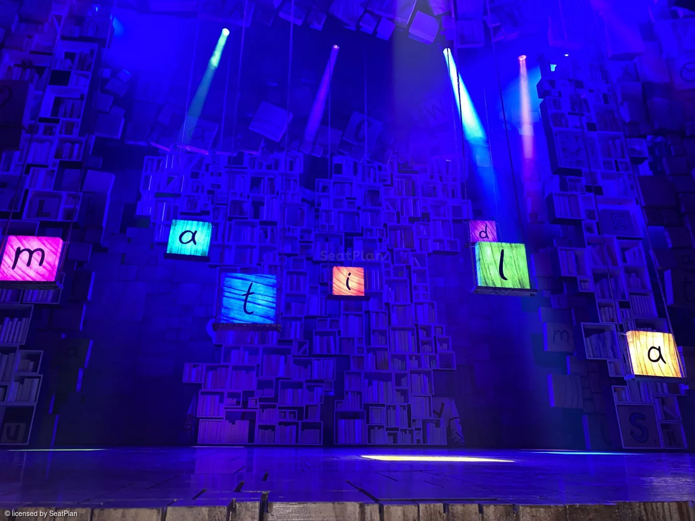 A seat view from the stalls. It shows the colourful alphabet set, which spells out the word 'Matilda' in the centre of the stage.